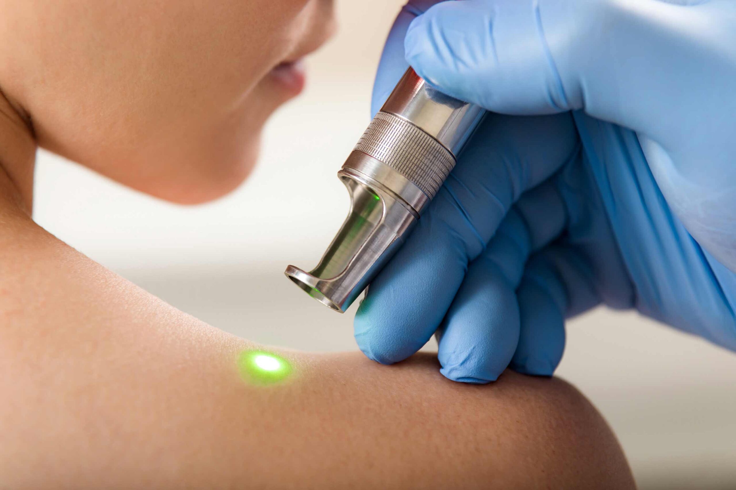 skin doctor examining an area on a womans shoulder